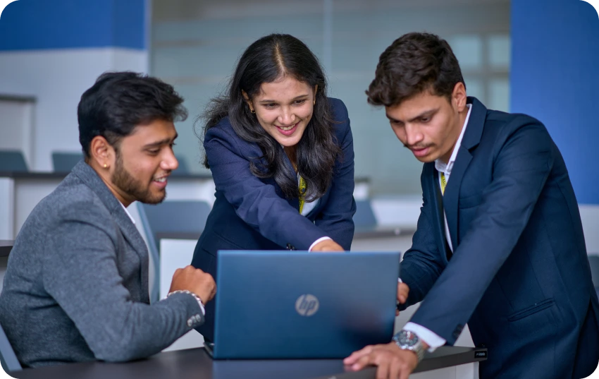 Two individuals working from a laptop.